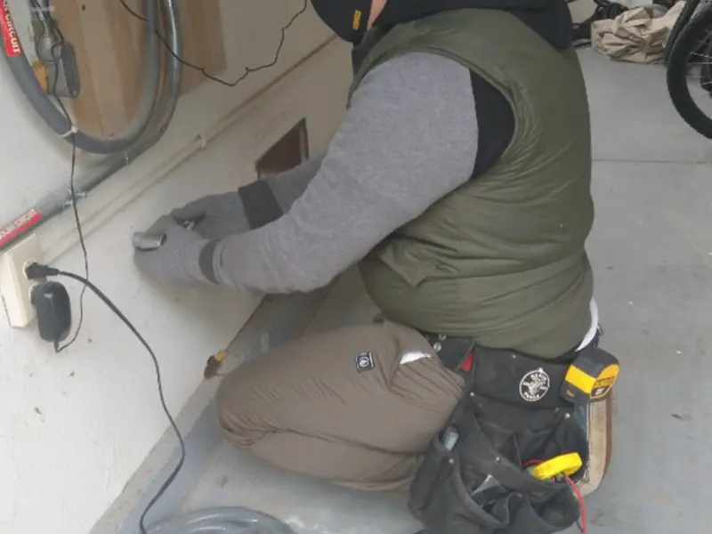 Electrician performing outlet wiring in a Roxbury garage